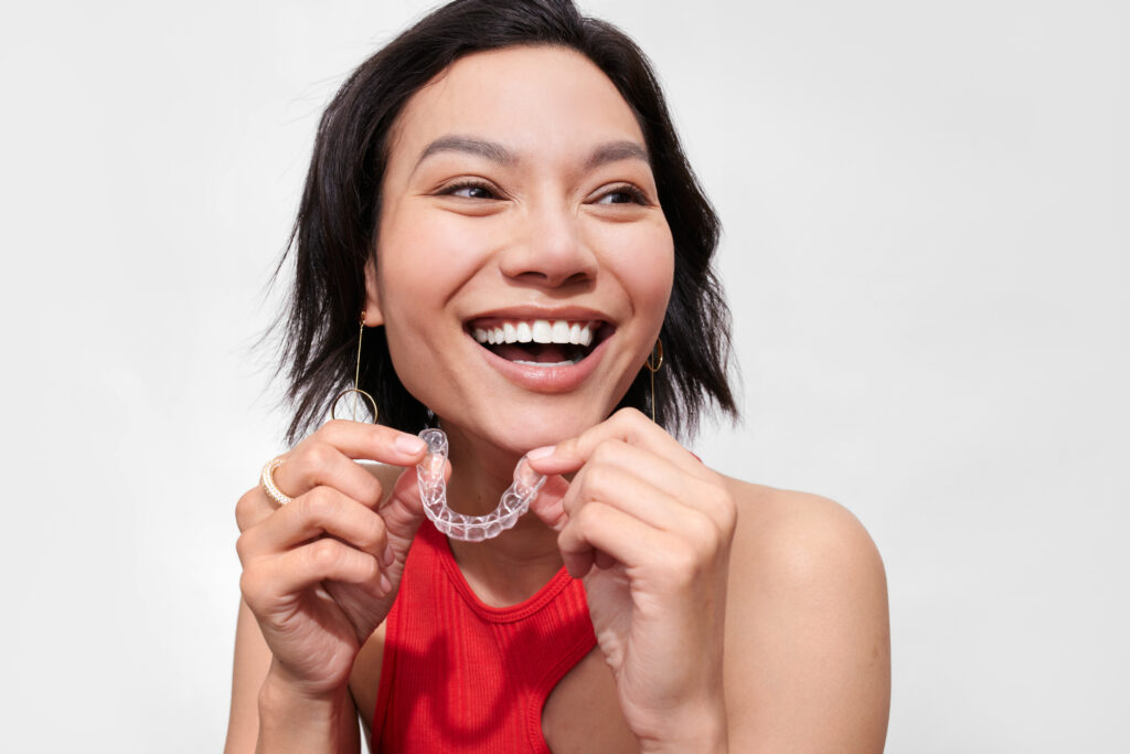 Smiling woman shows off her Candid Aligners.
